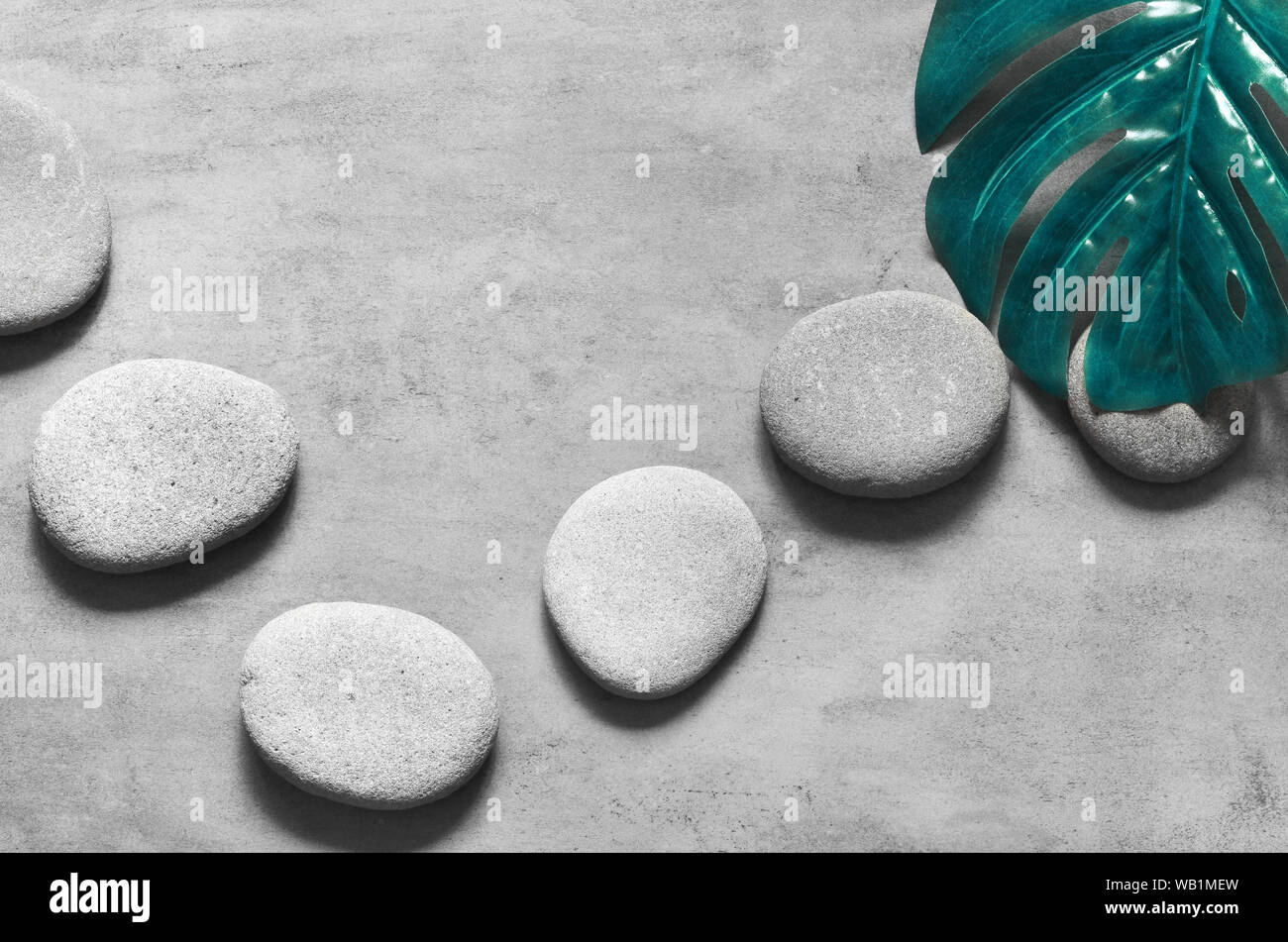 Flat lay composition with spa stones, green palm leaves on grey ...
