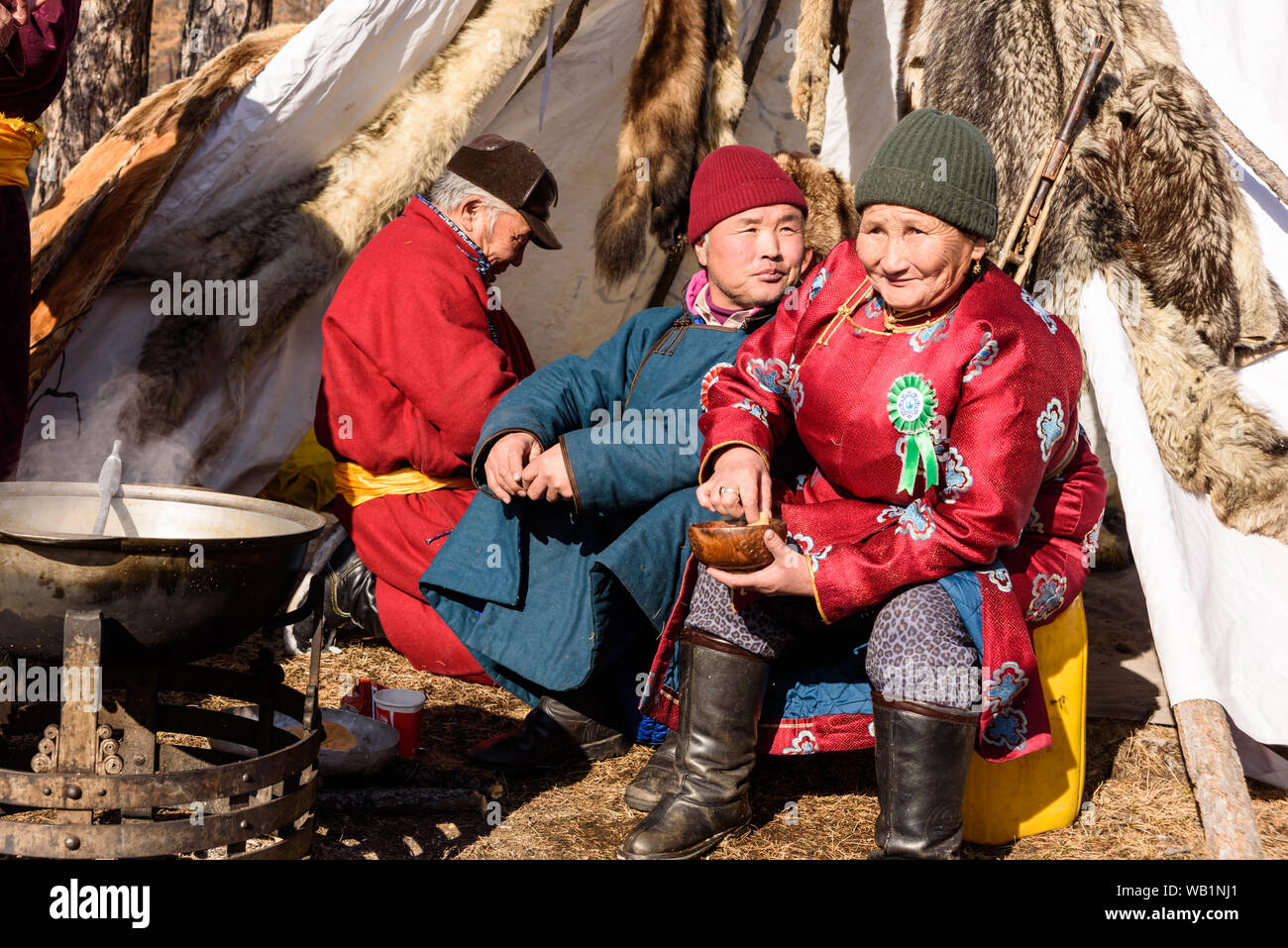 Hatgal, Mongolia, Febrary 25, 2018: older Mongolian lady and two men are sitting next to a stove near the yurt Stock Photo