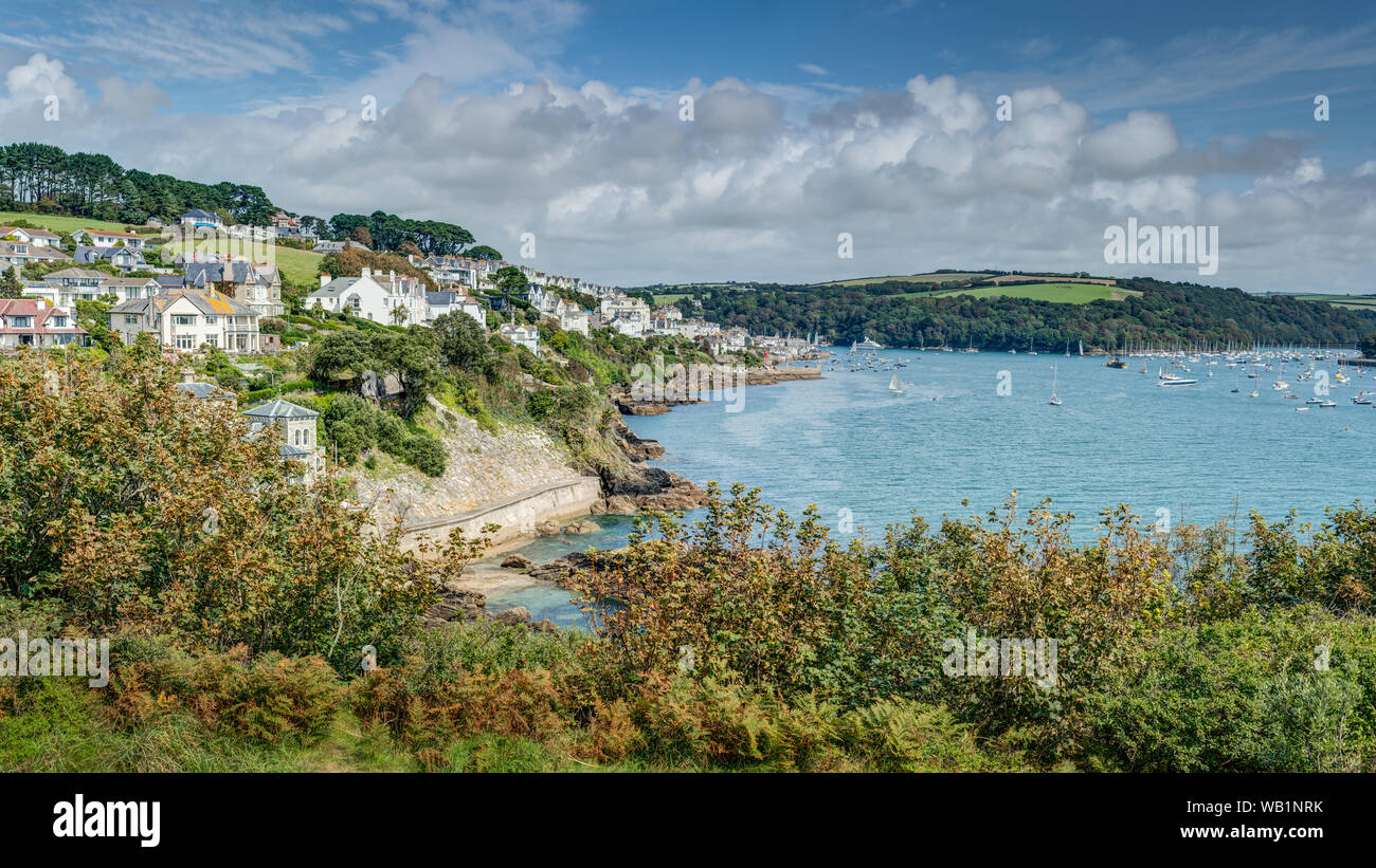 Very late summer in Cornwall at the Fowey Regatta looking down towards the town buildings and the estuary quayside moorings on a fine beautiful day. Stock Photo