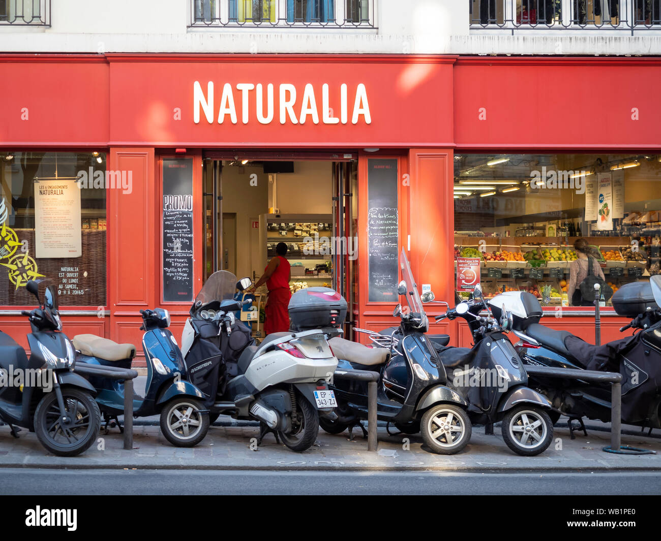 PARIS, FRANCE - AUGUST 03, 2018:  Scooters parked outside Naturalia Health Food Shop in   Rue Beaubourg Stock Photo