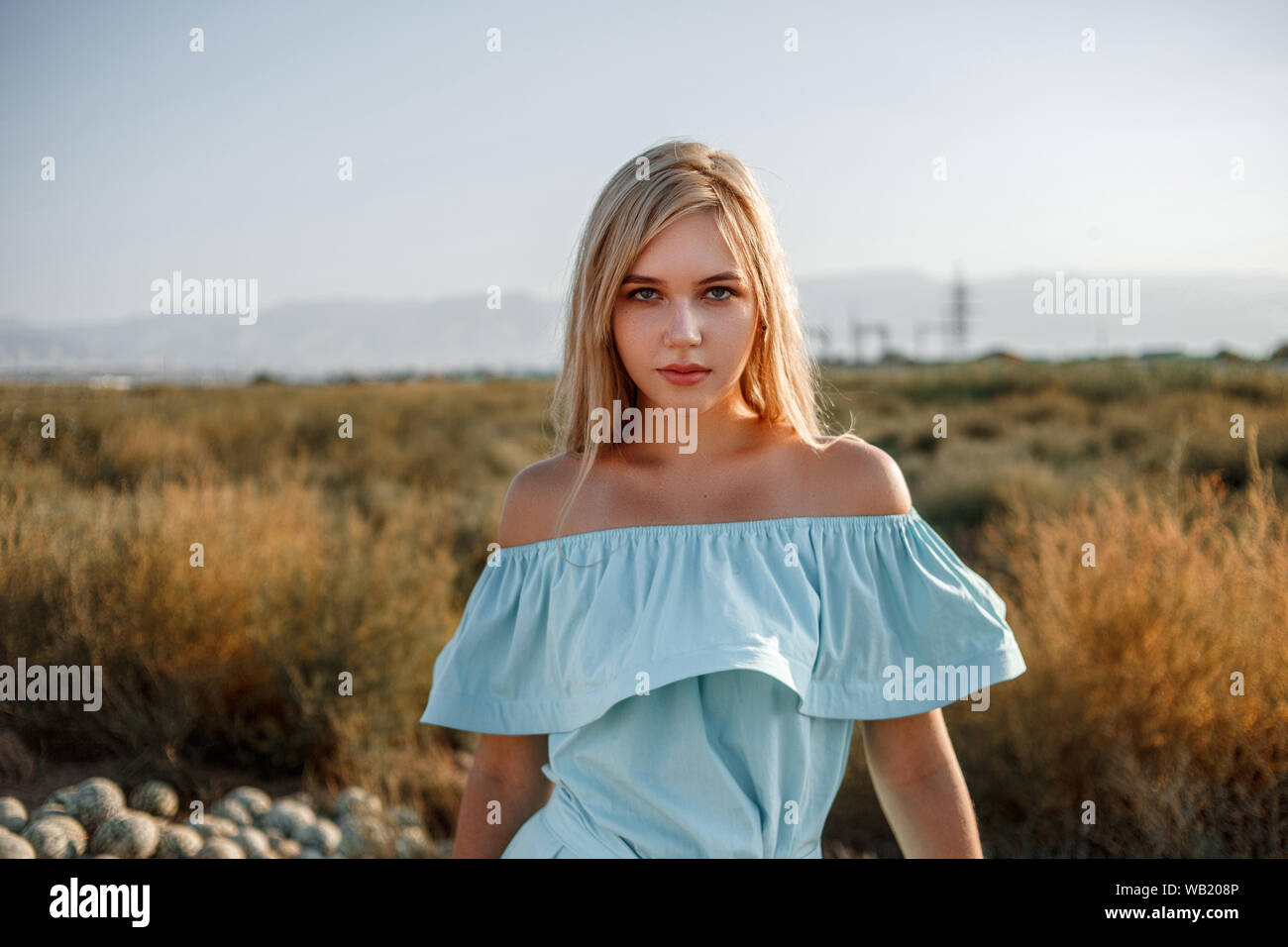 portrait of a young beautiful caucasian blonde girl in a light blue ...
