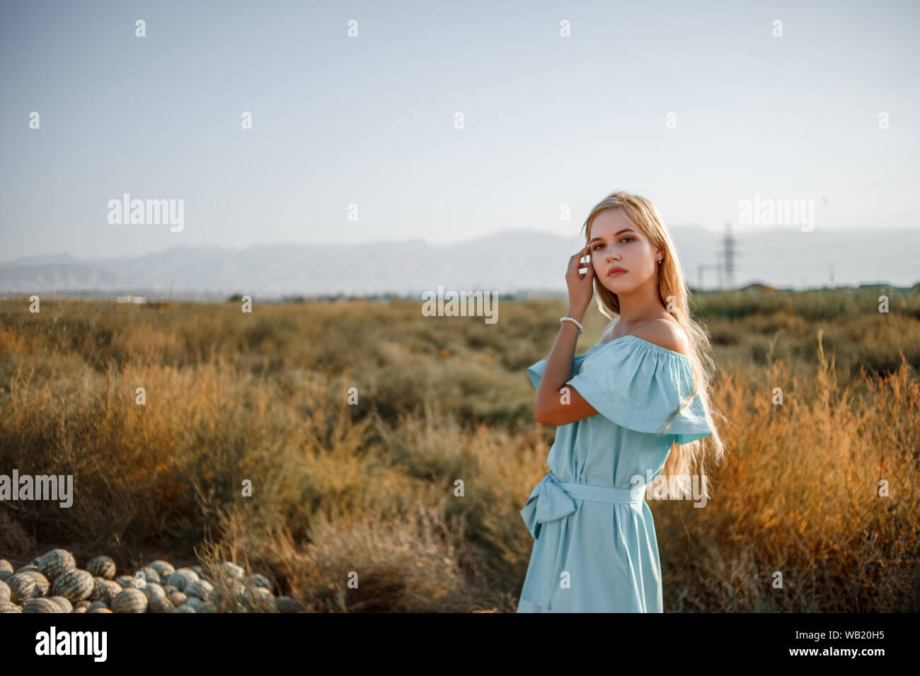 portrait of a young beautiful caucasian blonde girl in a light blue ...