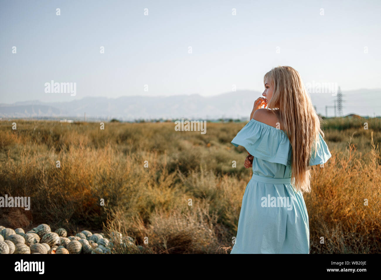 portrait of a young beautiful caucasian blonde girl in a light blue ...