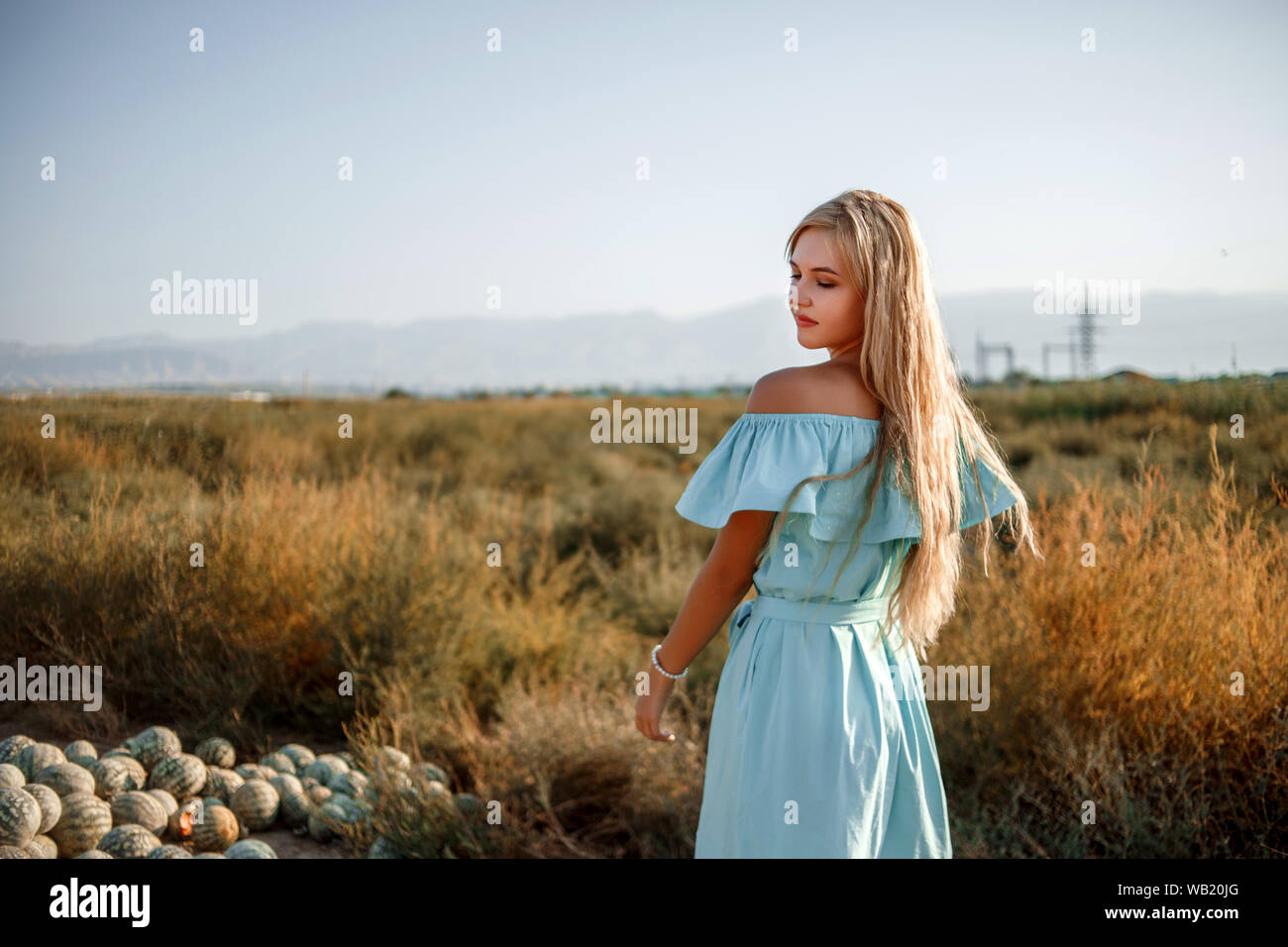 portrait of a young beautiful caucasian blonde girl in a light blue ...