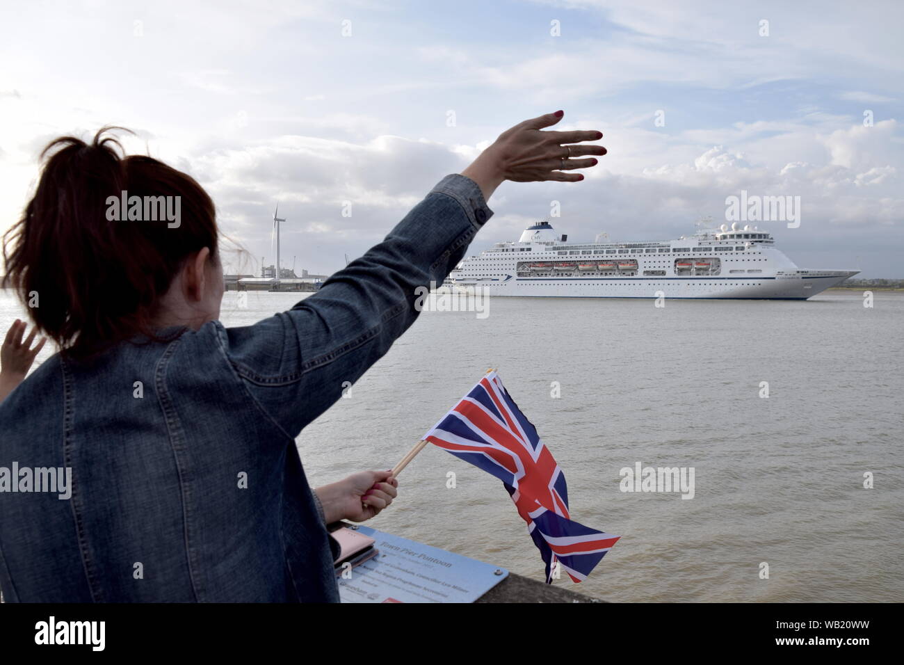 Columbus is a large luxury cruise ship. Onlookers wave goodbye, as she sails from London International Cruise Terminal, Tilbury. Stock Photo