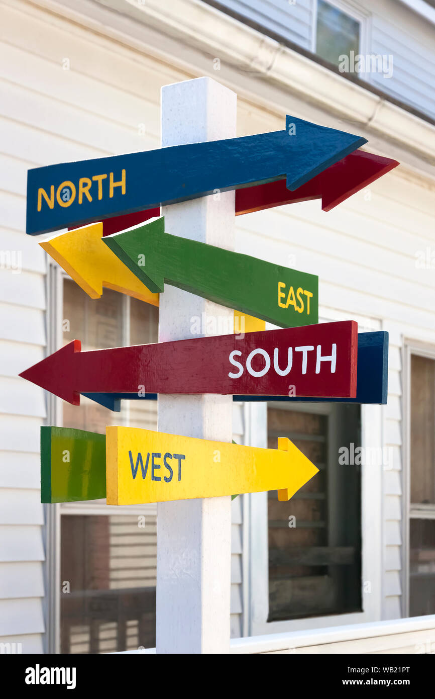 Signs with North, South, East, and West arrows pointing in different directions. Stock Photo