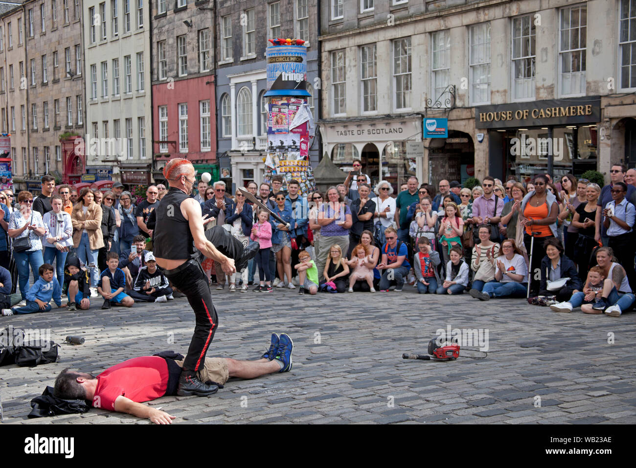Royal Mile, Edinburgh, Scotland, UK. 23rd August 2019. The Mighty Gareth in his 32nd year at the Fringe entertains the audience with juggling ball and knives. Stock Photo