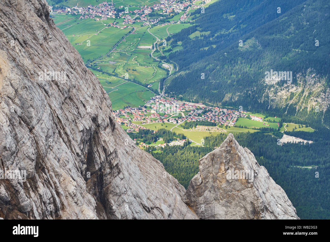 View from the top of a mountain in the Alps to a small village in the valley Stock Photo