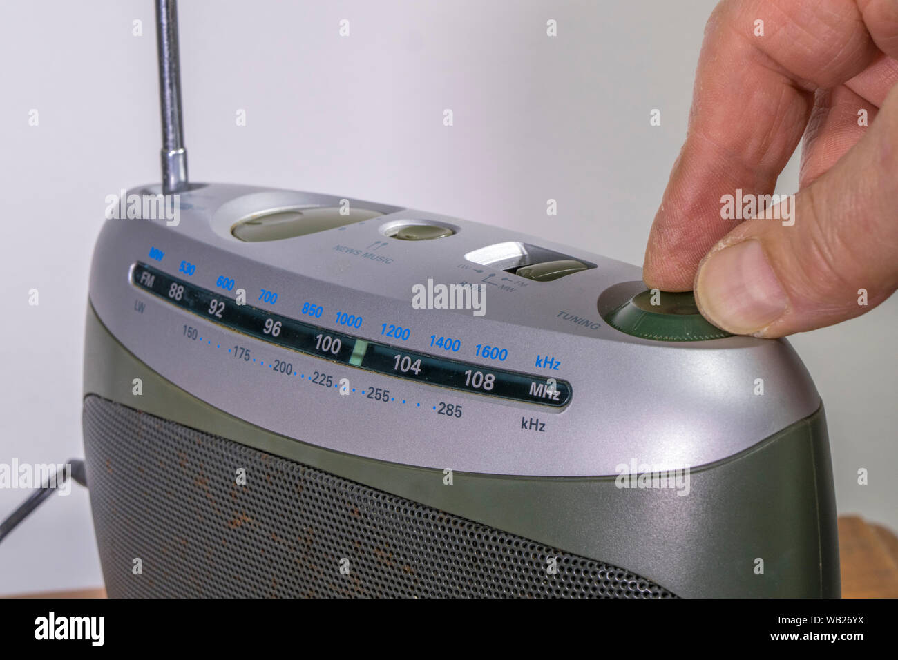 Close shot of a man’s hand turning a rotary control to tune in a ...