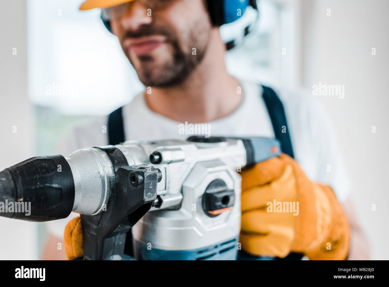 selective focus of handyman using hammer drill Stock Photo