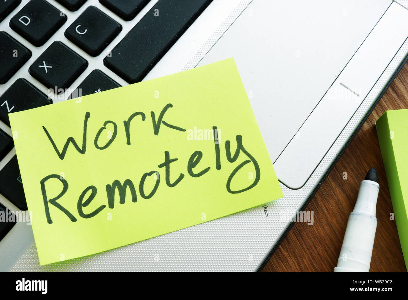 Work Remotely memo stick. Laptop for remote job. Stock Photo