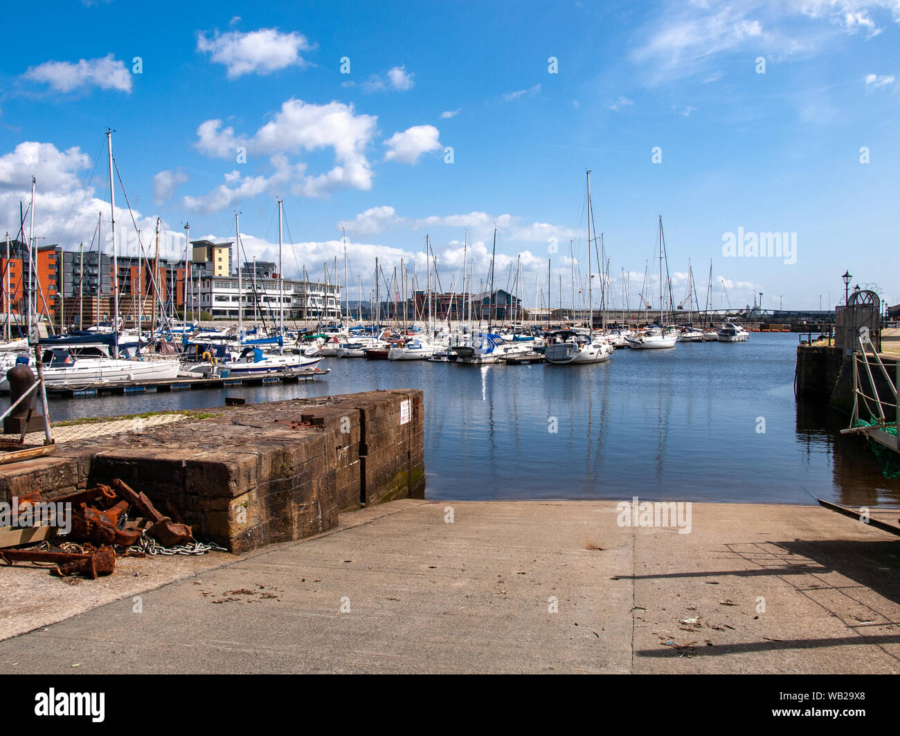 A slipway into Swansea Marina. Looking towards the River Tawe Barrage and bridge. Swansea, Wales, UK. Stock Photo