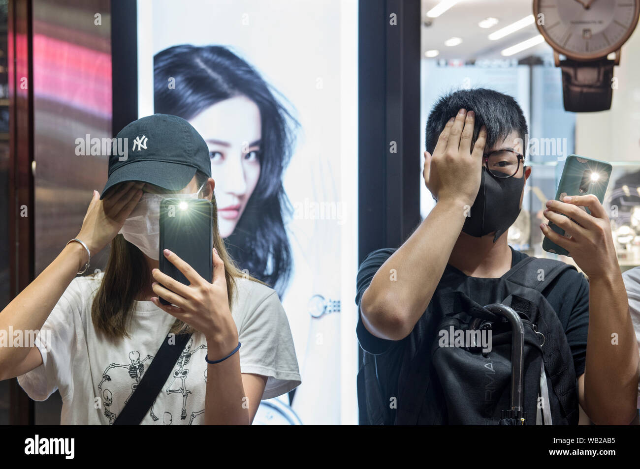 Protesters cover their right eye in front of a Chinese actress Liu Yifei commercial advert during the Hong Kong Way anti-government rally across Kowloon in Hong Kong. Mass demonstrations continue one more weekend in Hong Kong which began in June 2019 over a now-suspended extradition bill to China. Stock Photo