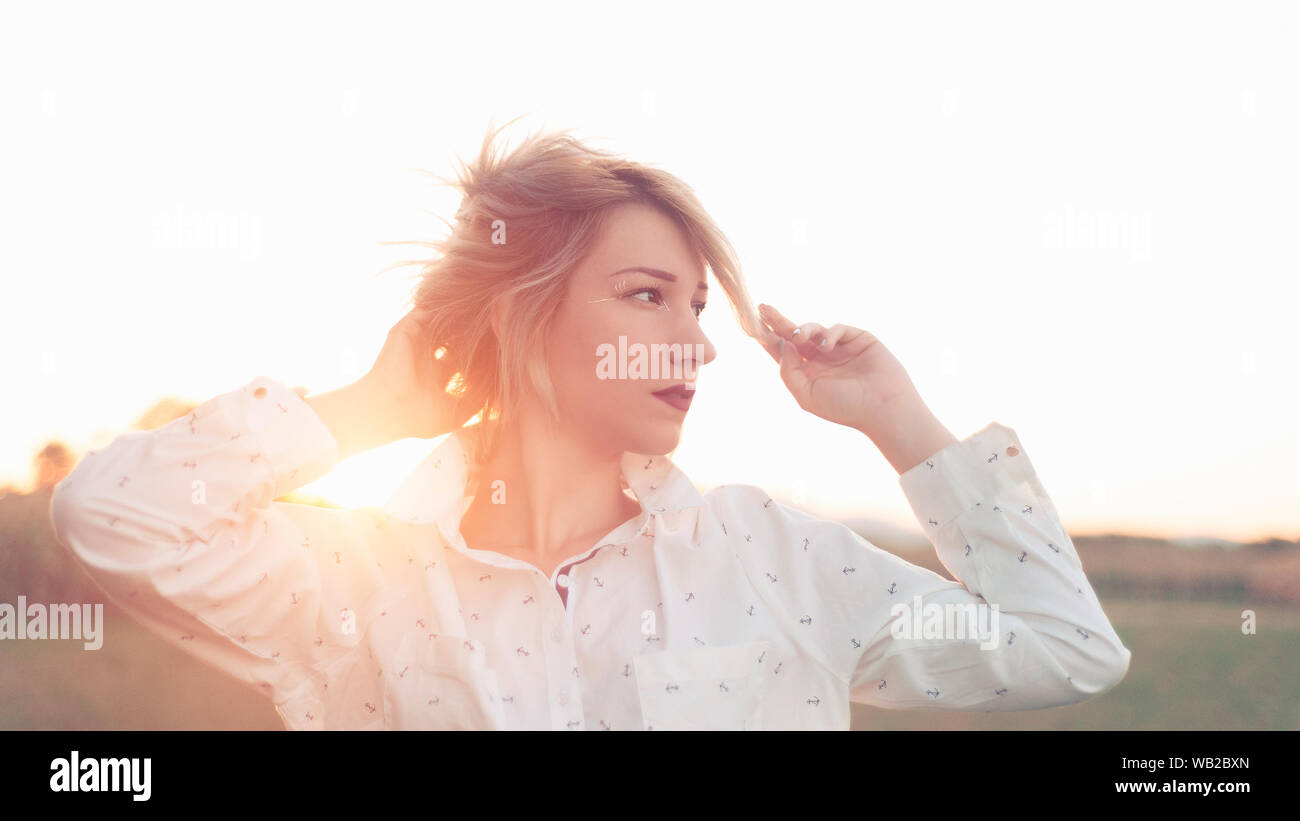 Young woman in white shirt and unique makeup in sunlight Stock Photo