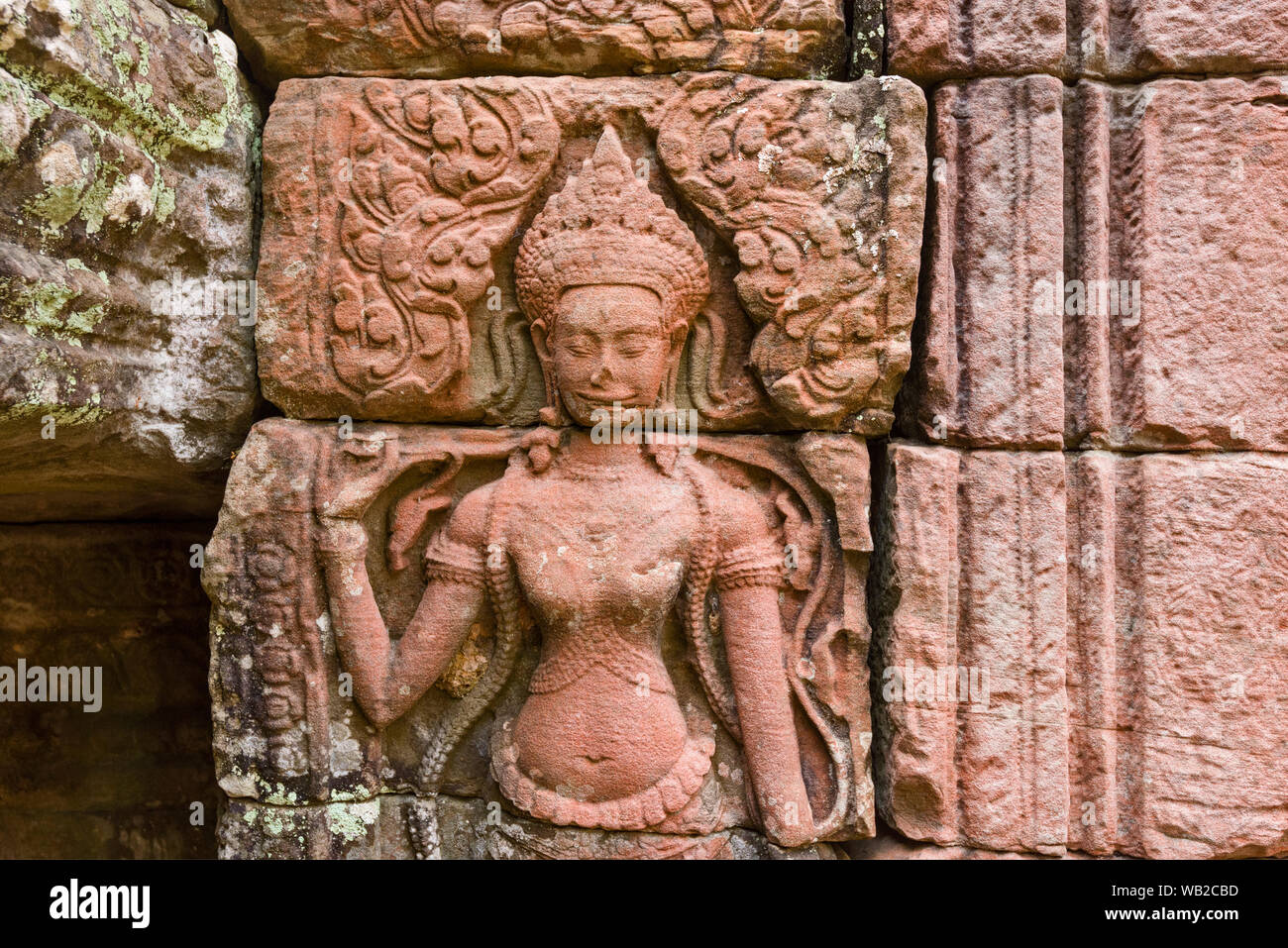 Devata are feminine deities or celestial nymphs with an enigmatic smile in Ta Prohm temple, Khmer ruins in Angkor Thom in Siem Reap Cambodia Stock Photo