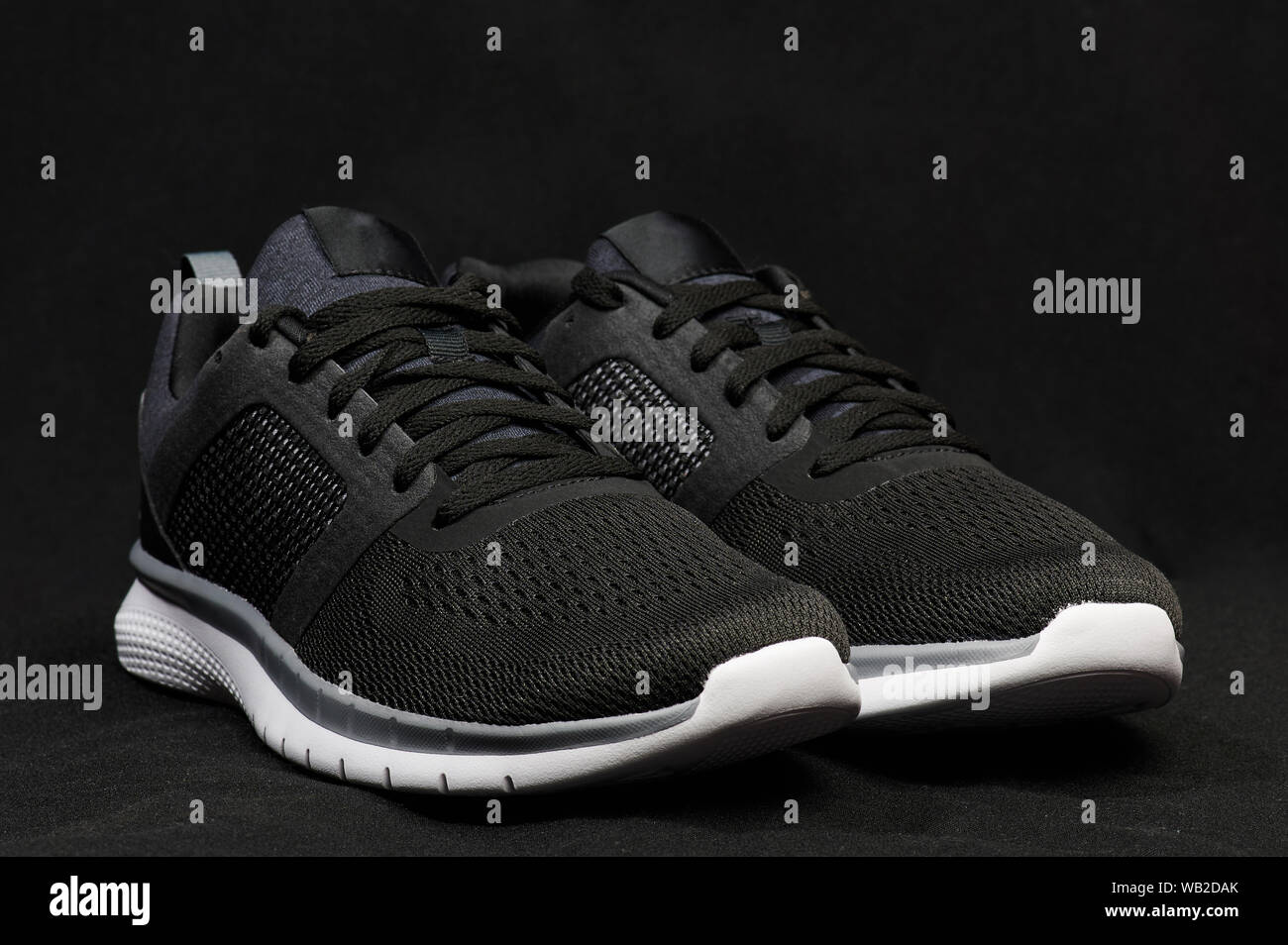Angle view of modern dark shoes on blurred gray studio background Stock Photo
