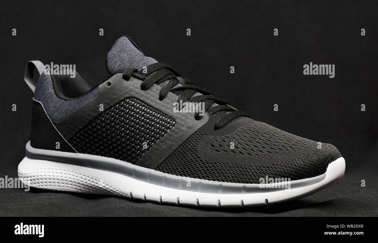 Grey sport modern shoe on dark blurred background Stock Photo