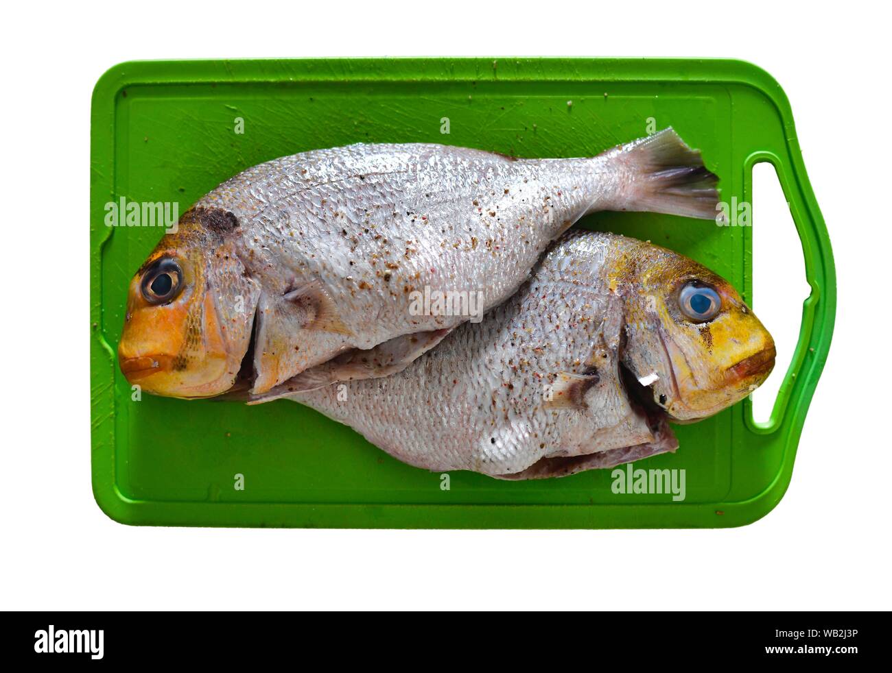 Two gilthead seabreams prepared for frying on a kitchen board, Portugal Stock Photo