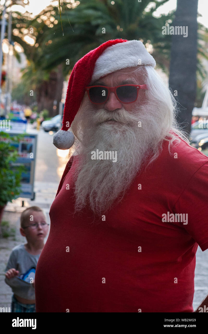 A Summer Santa: fancy dress on Obala Hrvatskog narodnog Preporoda, Split, Croatia Stock Photo