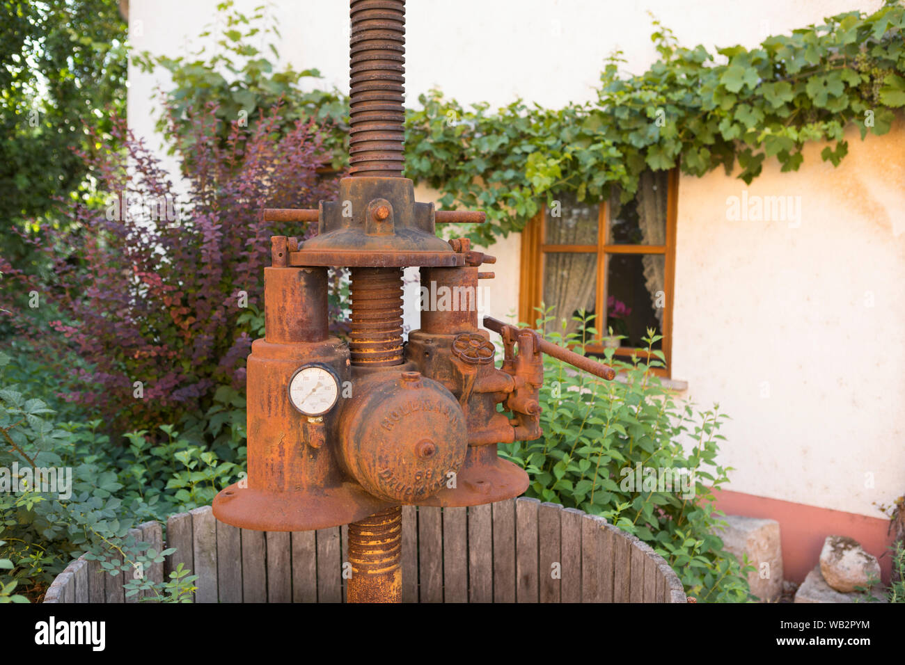 Vintage wine press used as decoration at front garden in a typical wine area, Rhine Valley, Nierstein, Germany Stock Photo