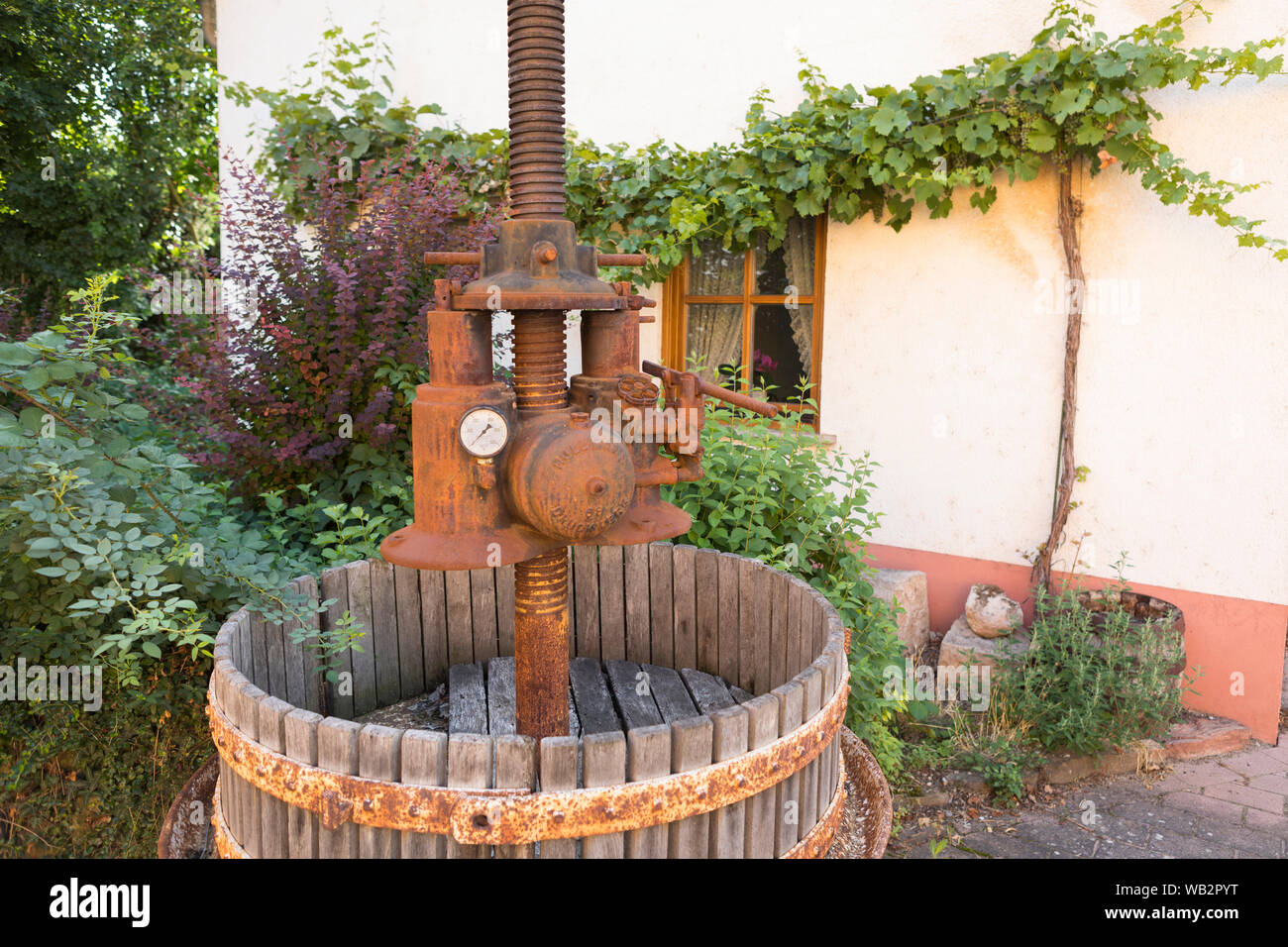 Vintage wine press used as decoration at front garden in a typical wine area, Rhine Valley, Nierstein, Germany Stock Photo