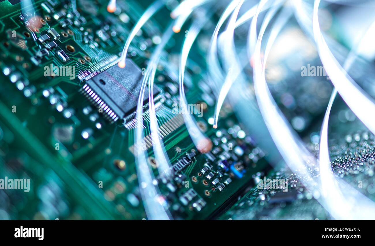 Digital communication, conceptual image. Fibre optics carrying data over electronic circuitry on a laptop computer. Stock Photo