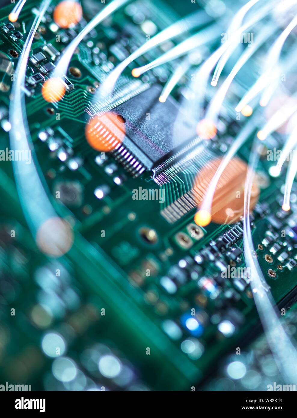 Digital communication, conceptual image. Fibre optics carrying data over electronic circuitry on a laptop computer. Stock Photo