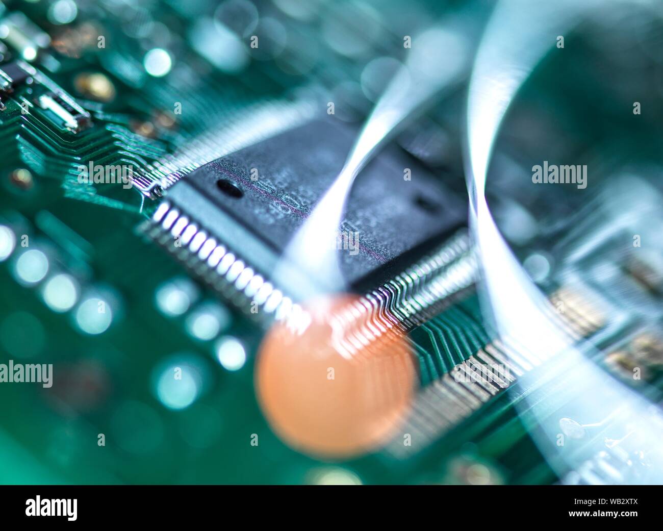 Digital communication, conceptual image. Fibre optics carrying data over electronic circuitry on a laptop computer. Stock Photo