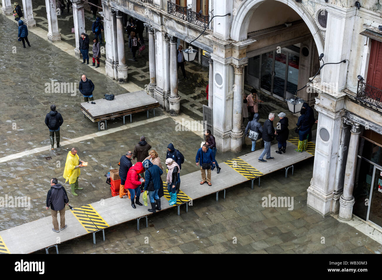People walking on elevated platforms during an Acqua alta (high water) event, Saint Mark's Square, Venice, Italy Stock Photo
