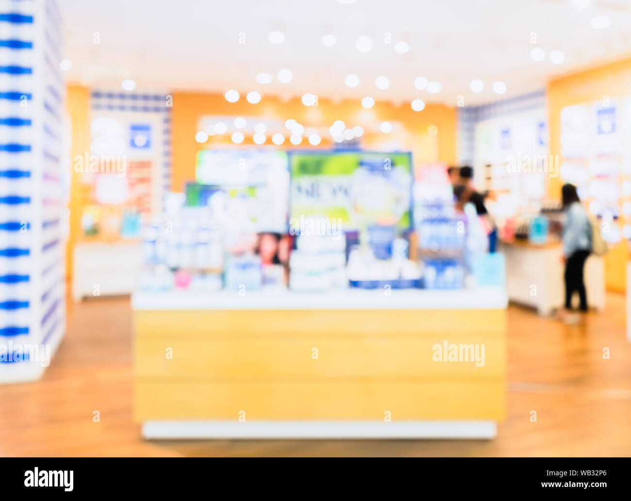 Abstract blurred photo of Cosmetic shop counter with bokeh for background. Blur interior of beauty store. Stock Photo