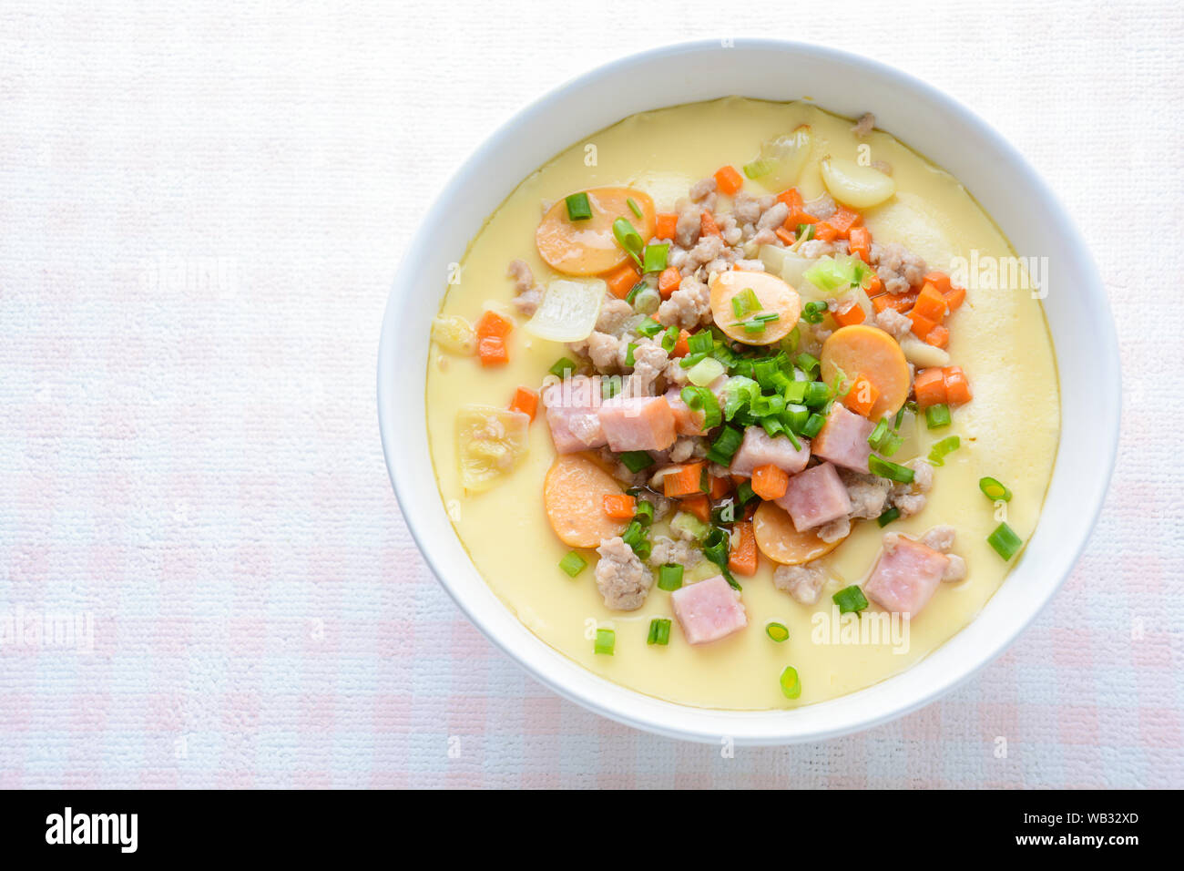 Steamed egg custard cuisine in a white bowl with minced pork, sausage