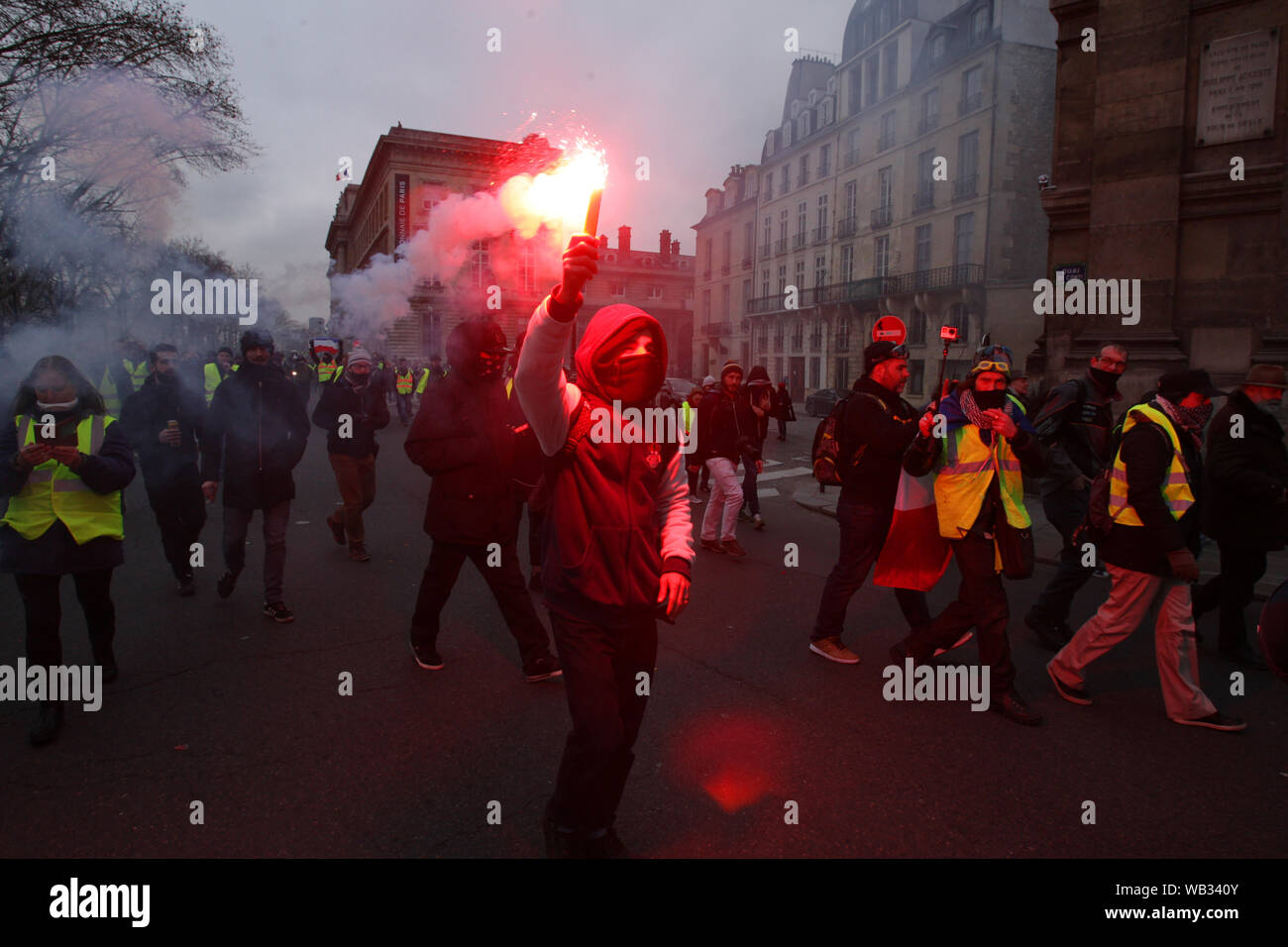 Demonstrators wearing yellow vest send yellow smoke into the air during march a protest in front of the city hall in Paris on January 5, 2019 in Pari Stock Photo