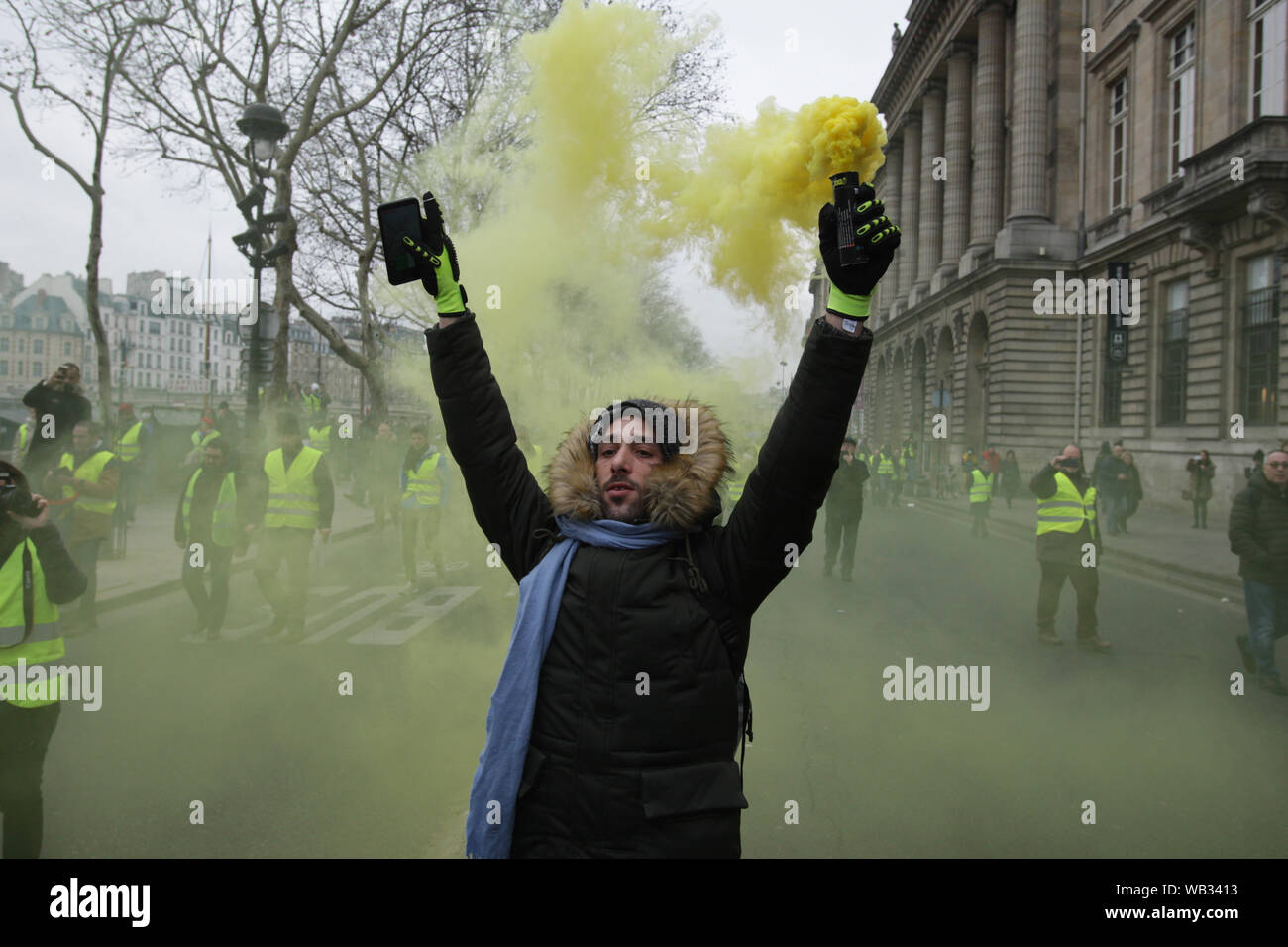 Demonstrators wearing yellow vest send yellow smoke into the air during march a protest in front of the city hall in Paris on January 5, 2019 in Pari Stock Photo
