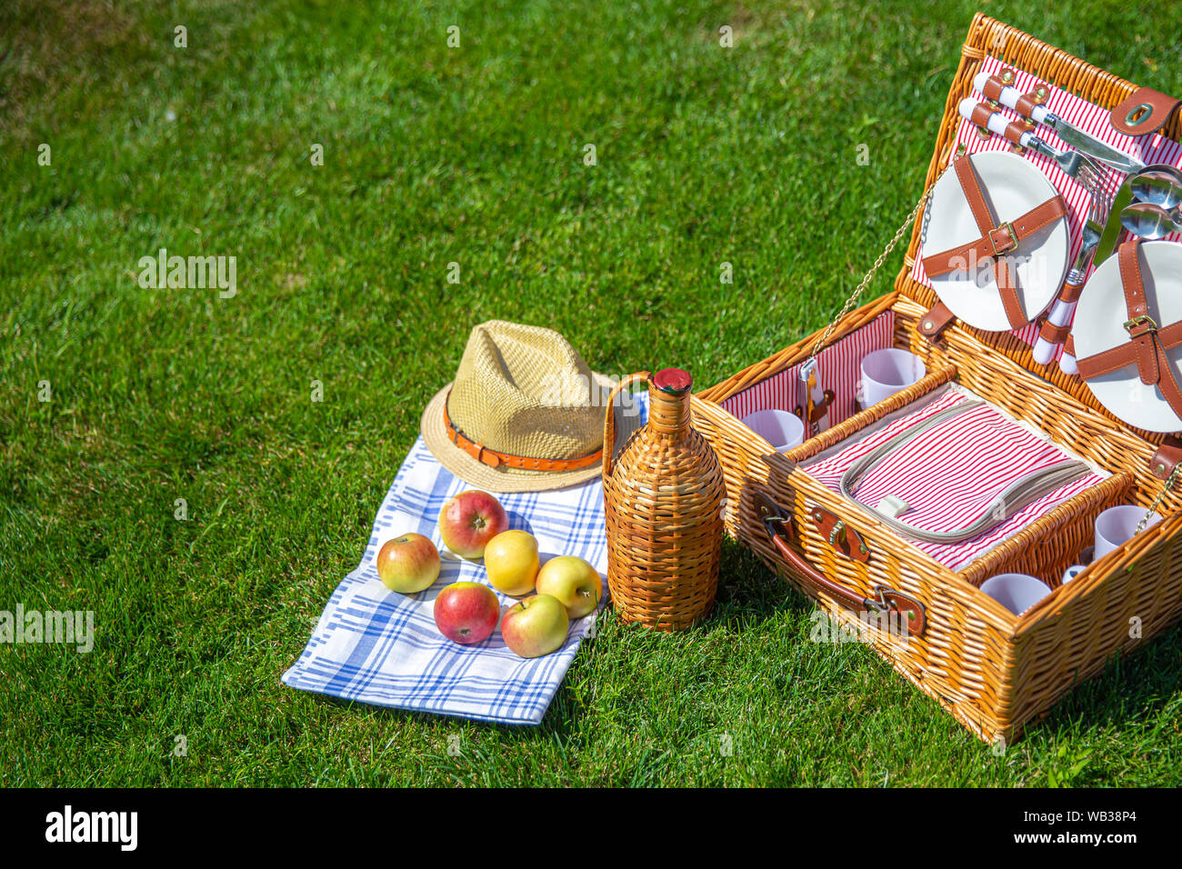Picnic basket with food on green sunny lawn Stock Photo - Alamy