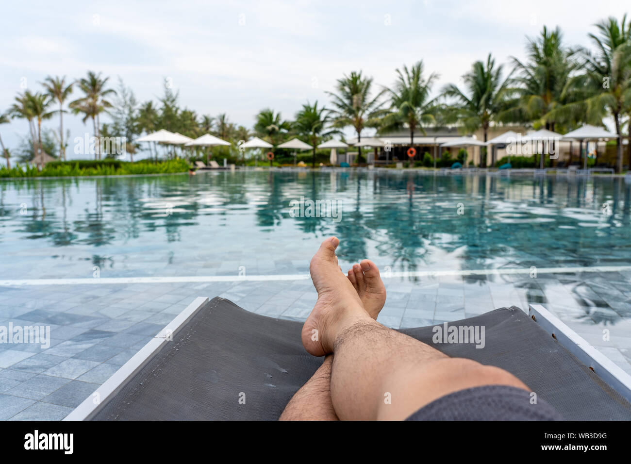 Closeup Of Human Legs On Chair At Beautiful Swimming Pool