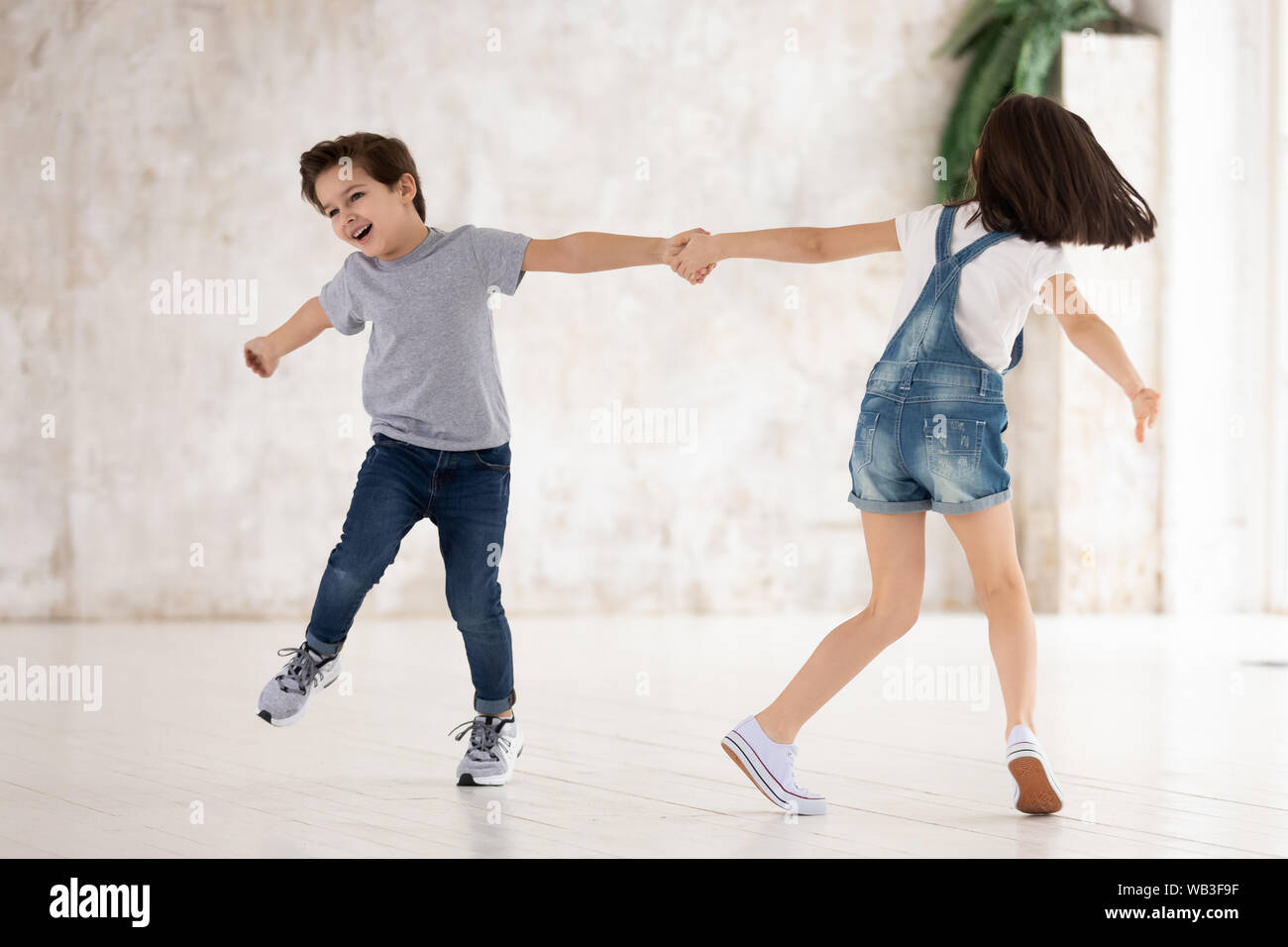 Excited funny kids siblings holding hands spinning playing at home Stock  Photo - Alamy