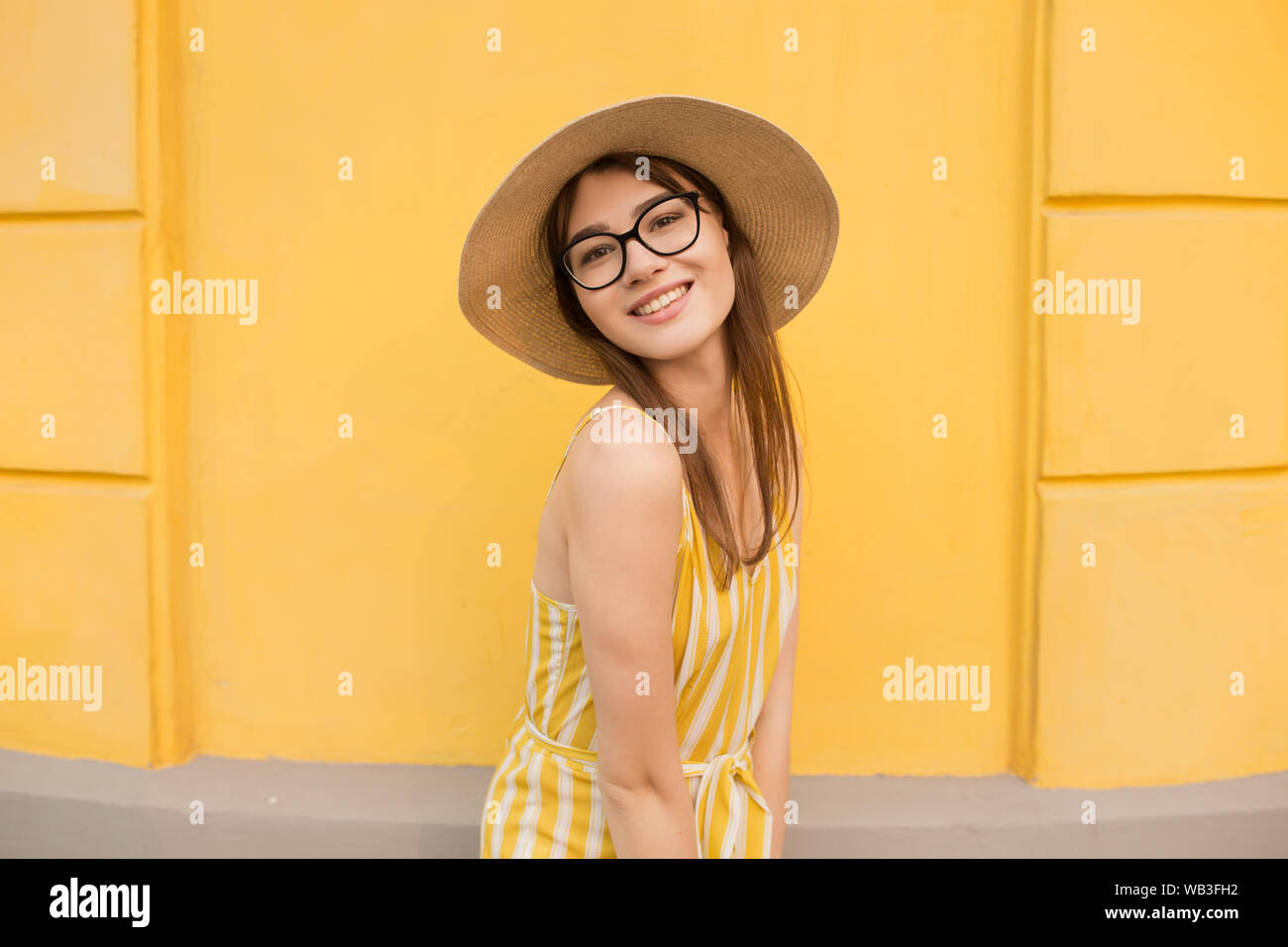 Fashion woman in stylish clothes on a background of a yellow wall. Bright photo with emotions. copy space Stock Photo
