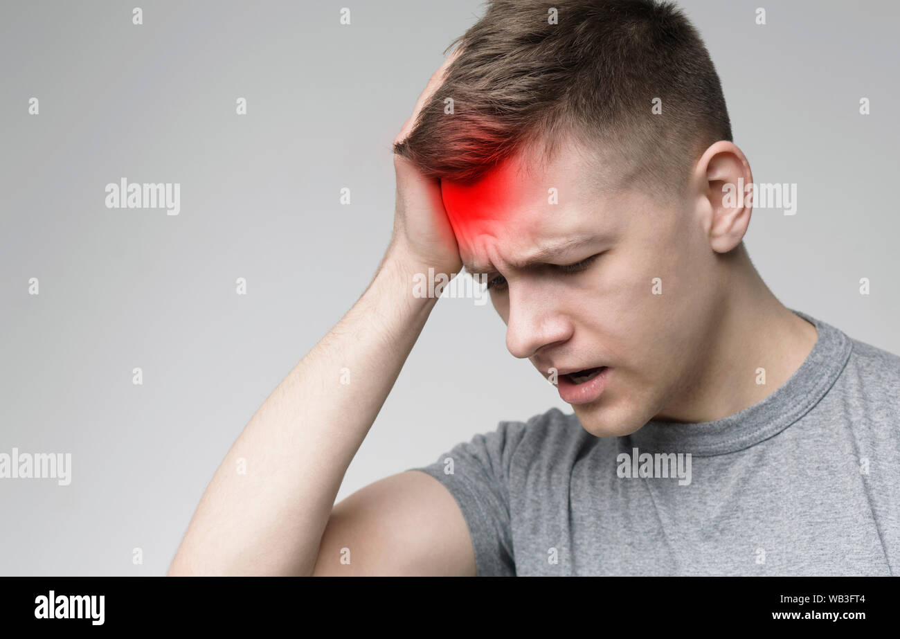 Frustrated handsome young man touching his head Stock Photo