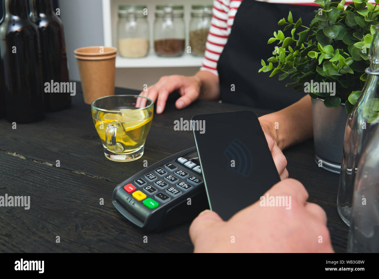 Customer making wireless or contactless payment using smartphone Stock Photo