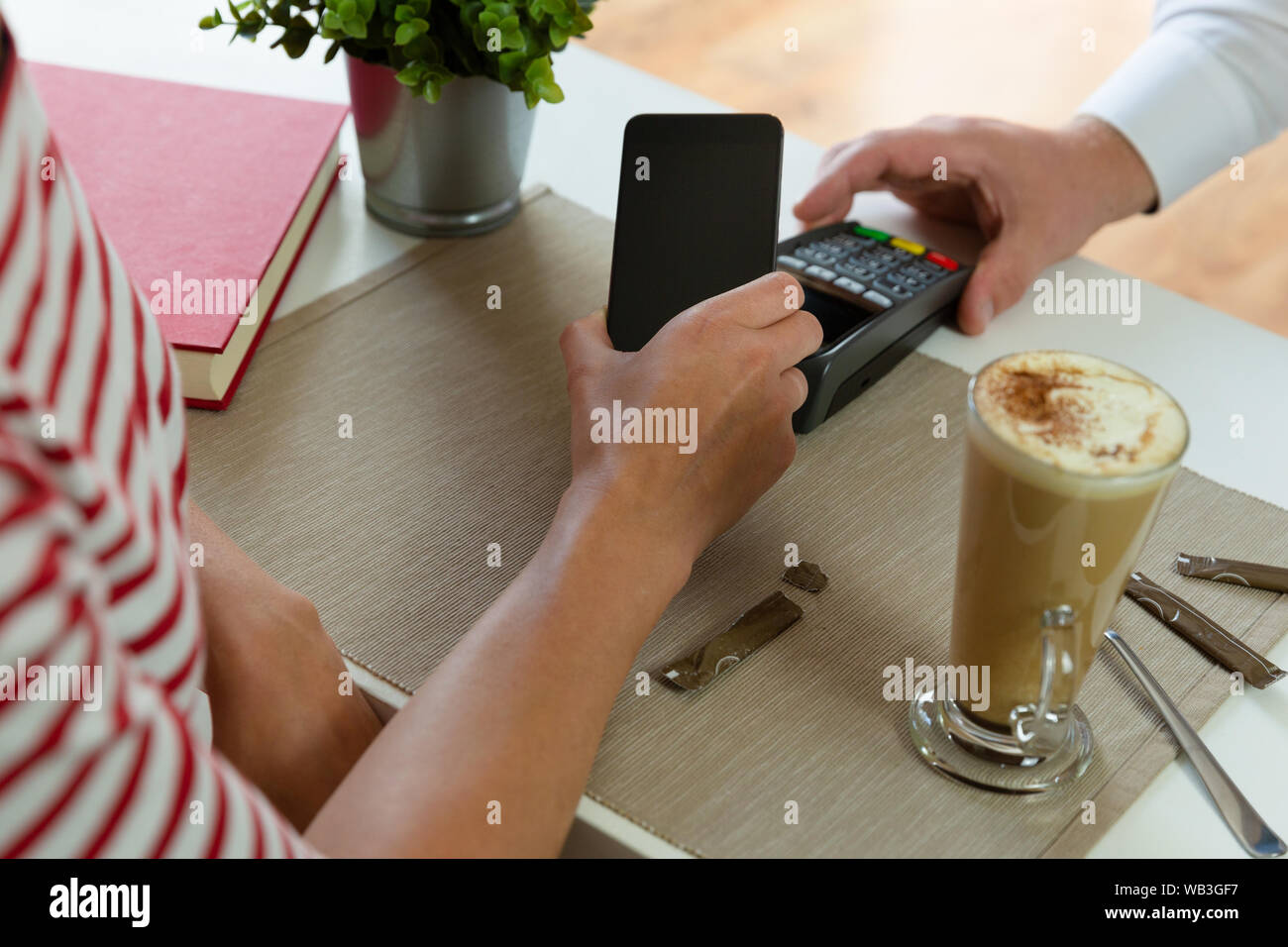 Customer making wireless or contactless payment using smartphone, nfc payment Stock Photo