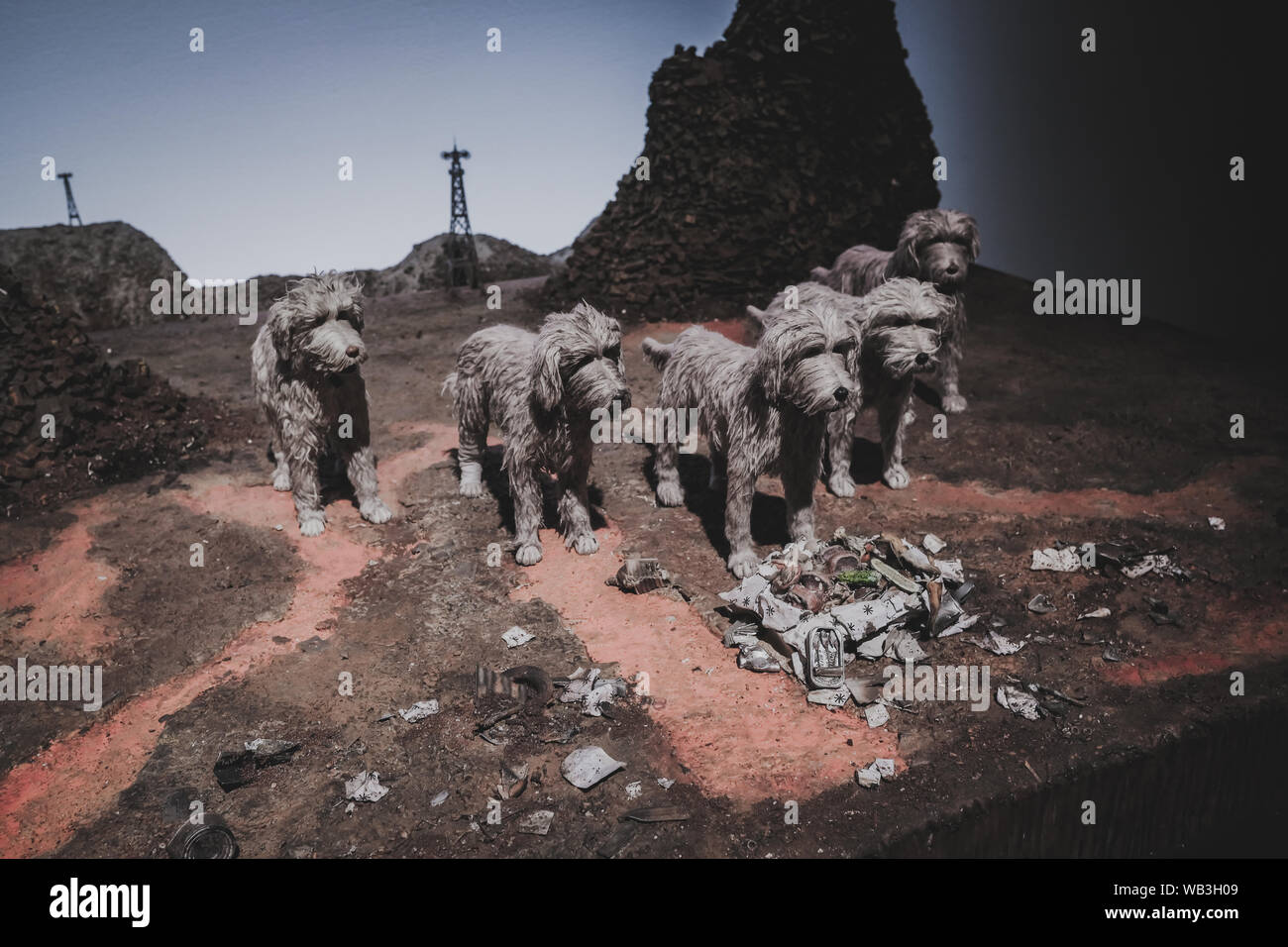 Formation of five dogs with grey hair in a junkyard diorama, on display