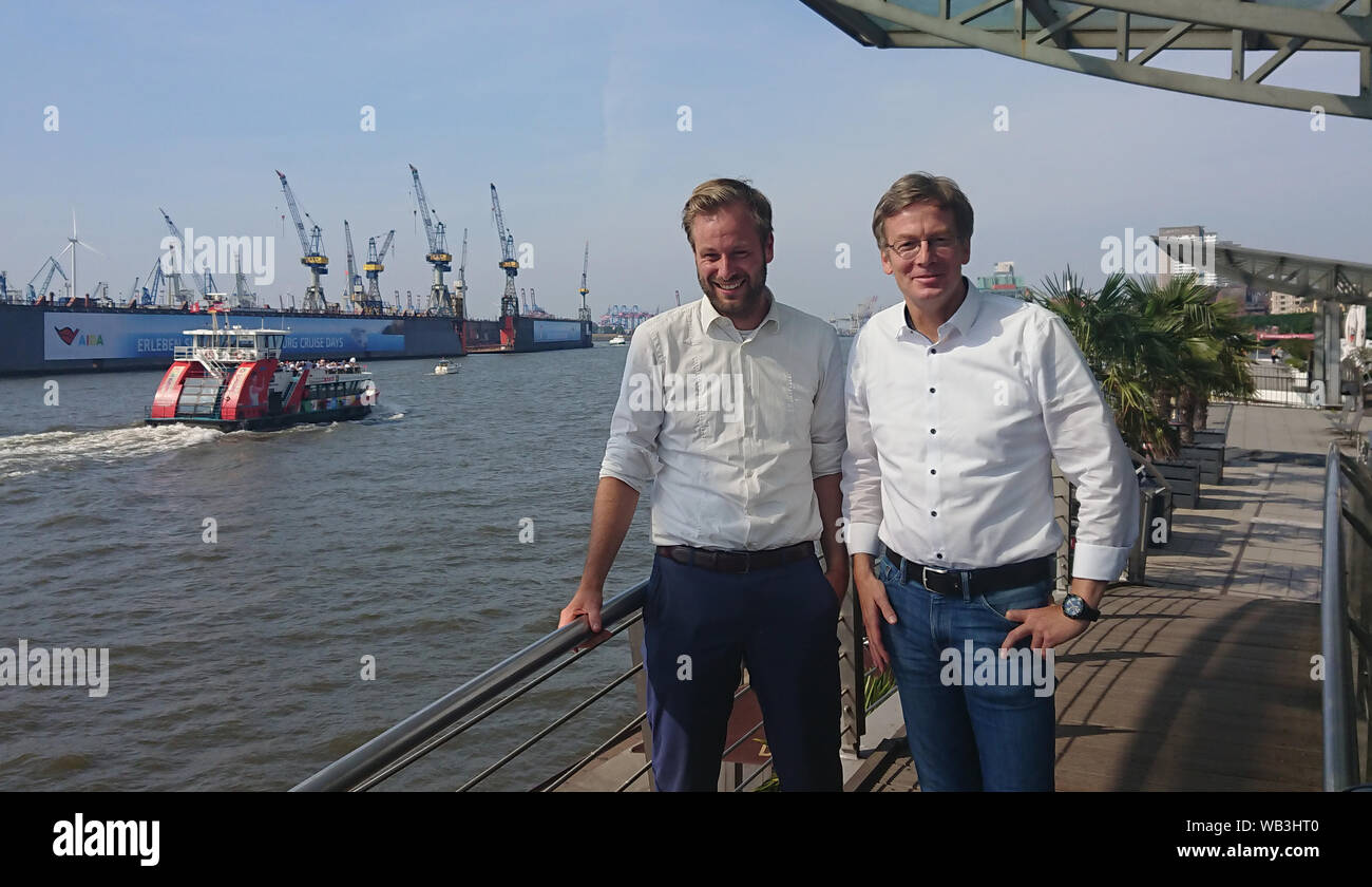 23 August 2019, Hamburg: The faction leader of Bündnis 90/Die Grünen, Anjes Tjarks (l), and Dirk Kienscherf, faction leader of the SPD, are standing at the Landungsbrücken. Social Democrats and Greens in Hamburg and Rotterdam want to promote cooperation between the two port cities in reducing air pollutants emitted by seagoing ships. Photo: Martin Fischer/dpa Stock Photo