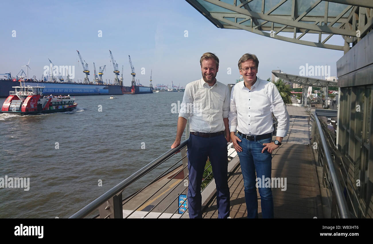 23 August 2019, Hamburg: The faction leader of Bündnis 90/Die Grünen, Anjes Tjarks (l), and Dirk Kienscherf, faction leader of the SPD, are standing at the Landungsbrücken. Social Democrats and Greens in Hamburg and Rotterdam want to promote cooperation between the two port cities in reducing air pollutants emitted by seagoing ships. Photo: Martin Fischer/dpa Stock Photo