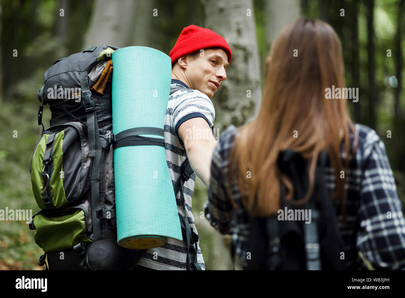 Travel couple with map and backpacks in the forest, freedom and active travel concept Stock Photo