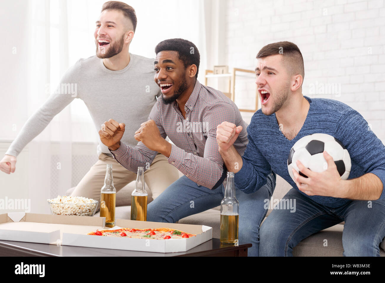 Watch football match. Men shouting at home Stock Photo - Alamy