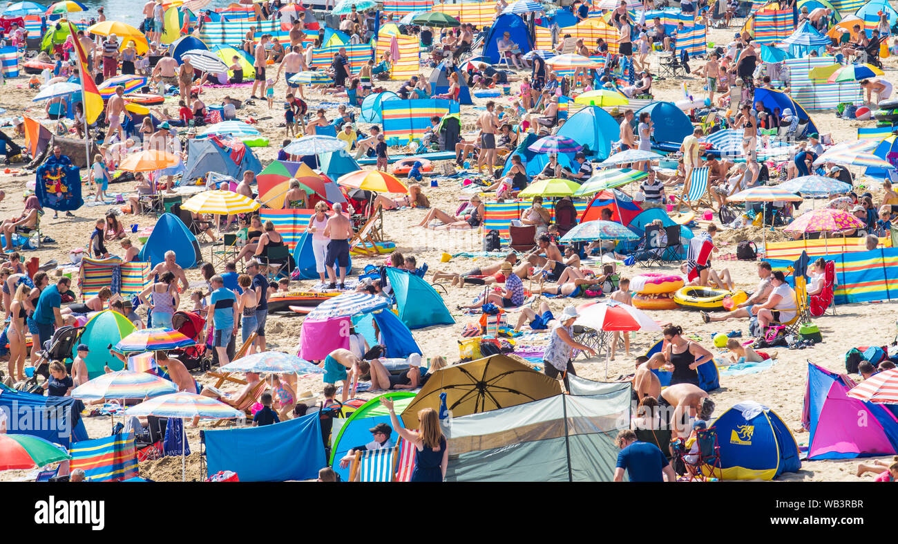 Lyme Regis, Dorset, UK. 24th August 2019. UK Weather: There was barely a space on the sandy beach by 11am as crowds of holidaymakers and sunseekers flock to the seaside resort of Lyme Regis to bask in sizzling hot sunshine on Bank Holiday Satuday. Credit: Celia McMahon/Alamy Live News. Stock Photo