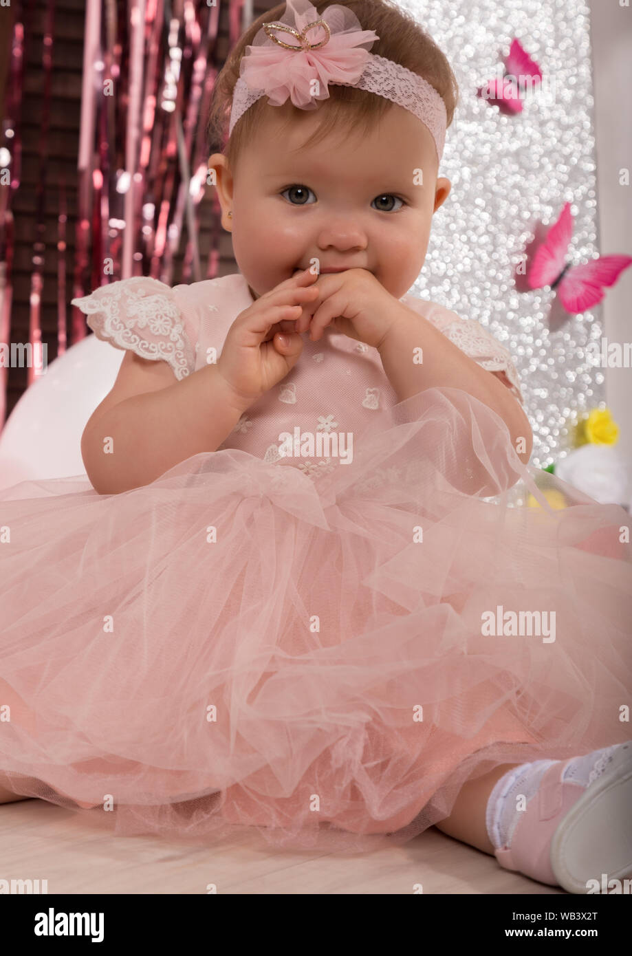 beautiful fashionable little baby in pink dress. little princess poses like a doll Stock Photo