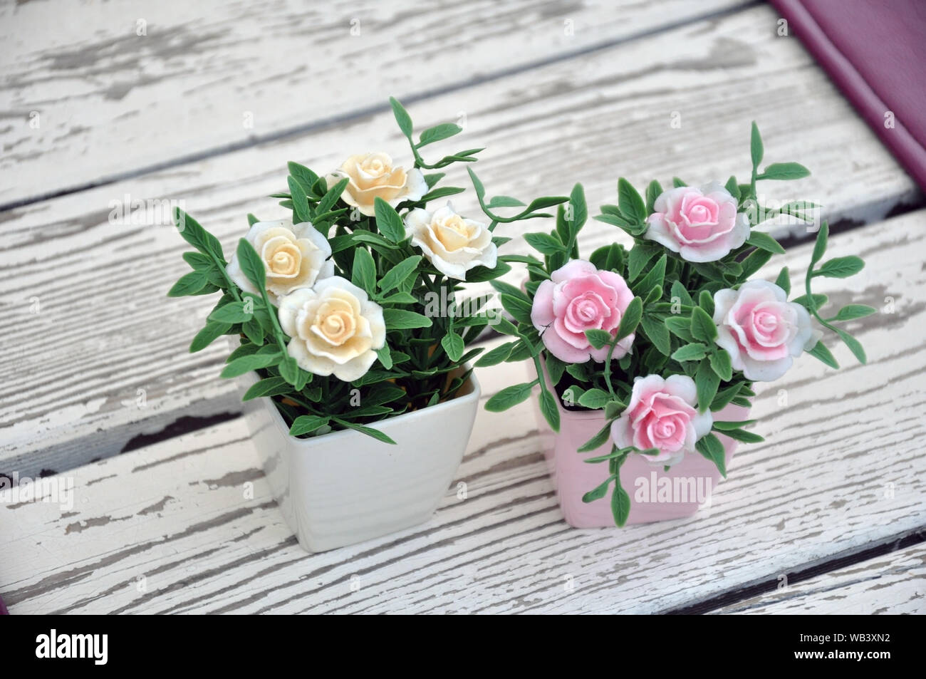 Artificial flowers in pots on the table. Table setting Stock Photo