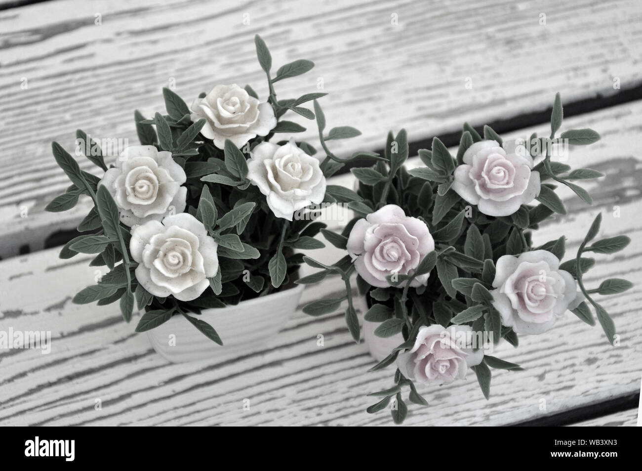 Artificial flowers in pots on the table. Background Stock Photo