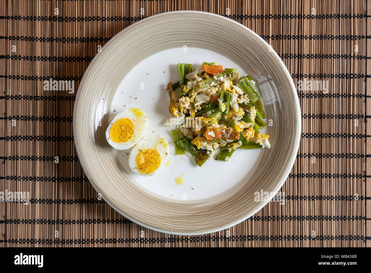 a dish with boiled eggs and scrambled eggs with green peppers Stock Photo